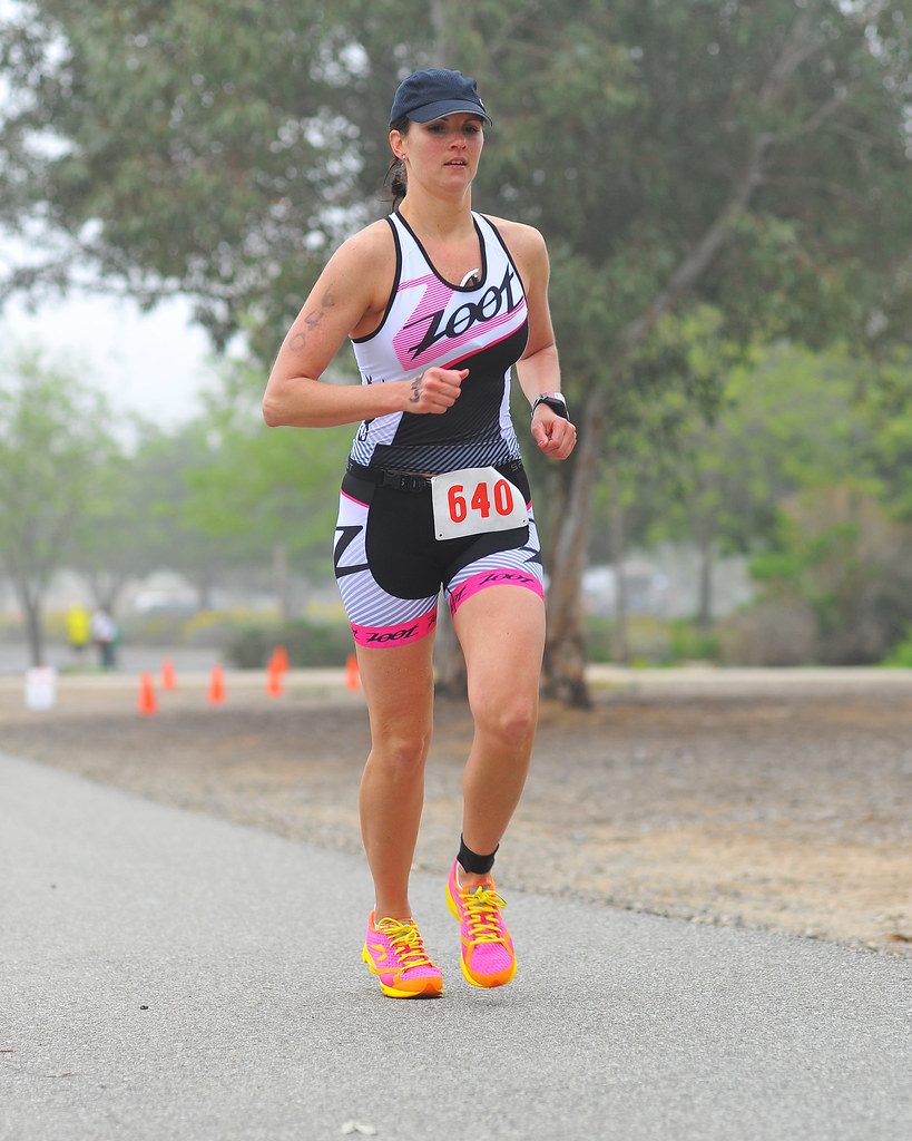 Female triathlete running on park path