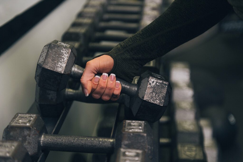 Hand lifting dumbbell from rack