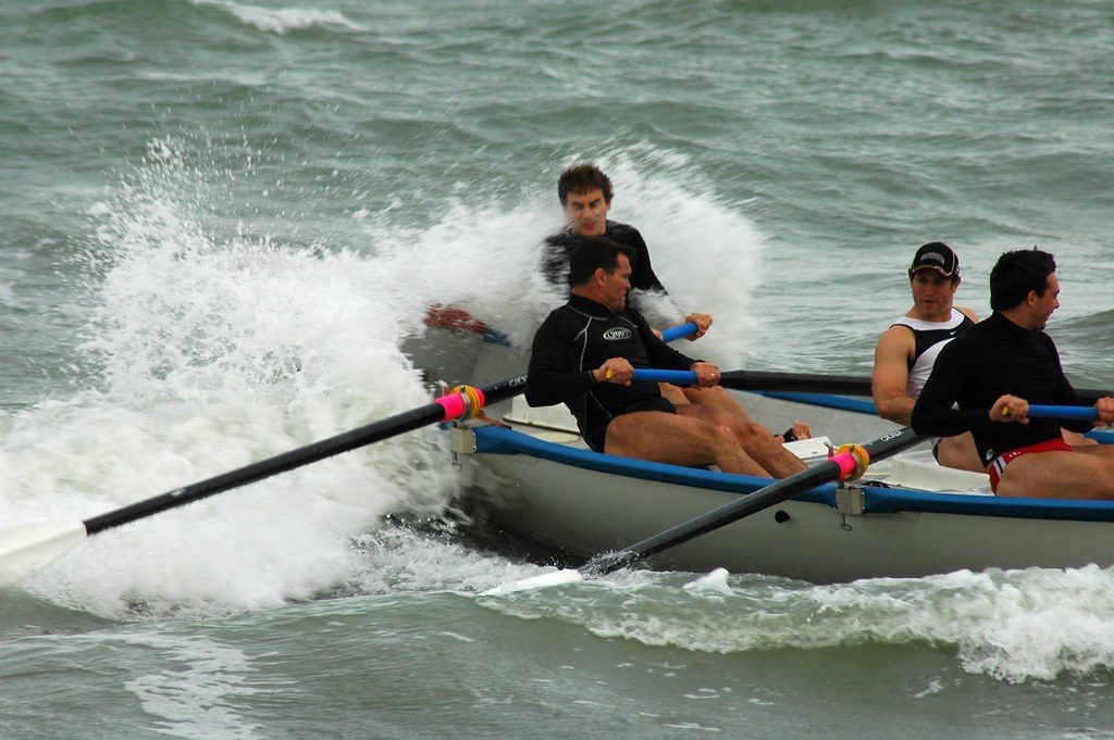 Surf rowing boat crashing through waves