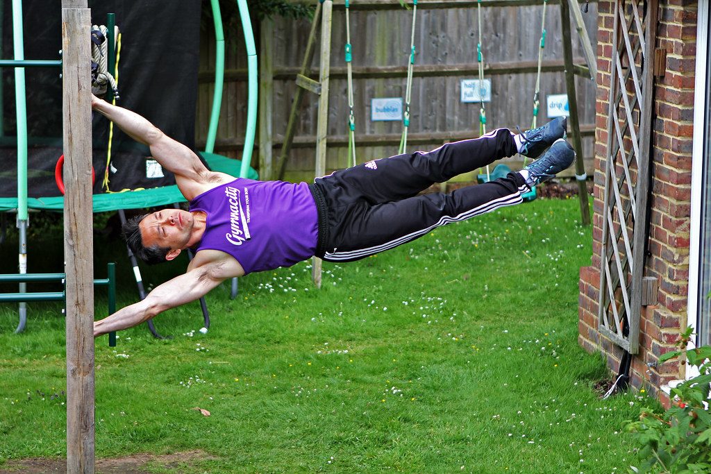 Man doing human flag in backyard