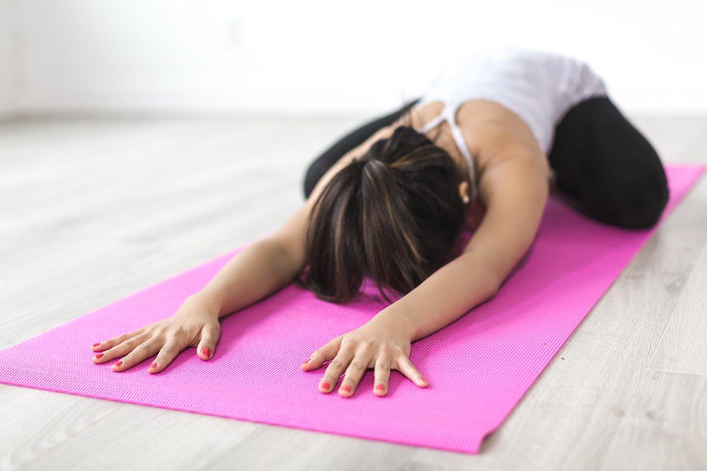 Woman in child's pose on pink mat