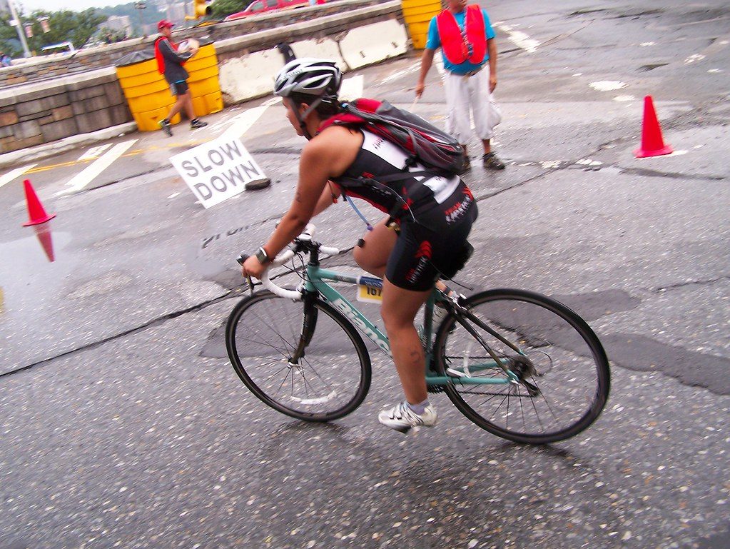 Triathlete cycling on wet race course