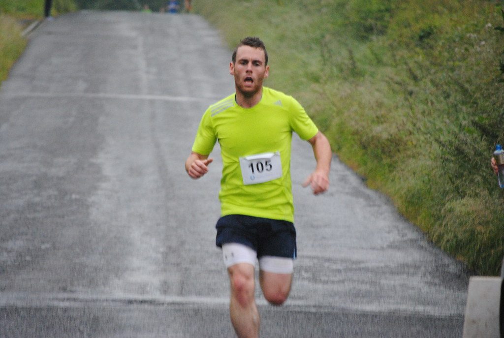 Runner racing uphill on road