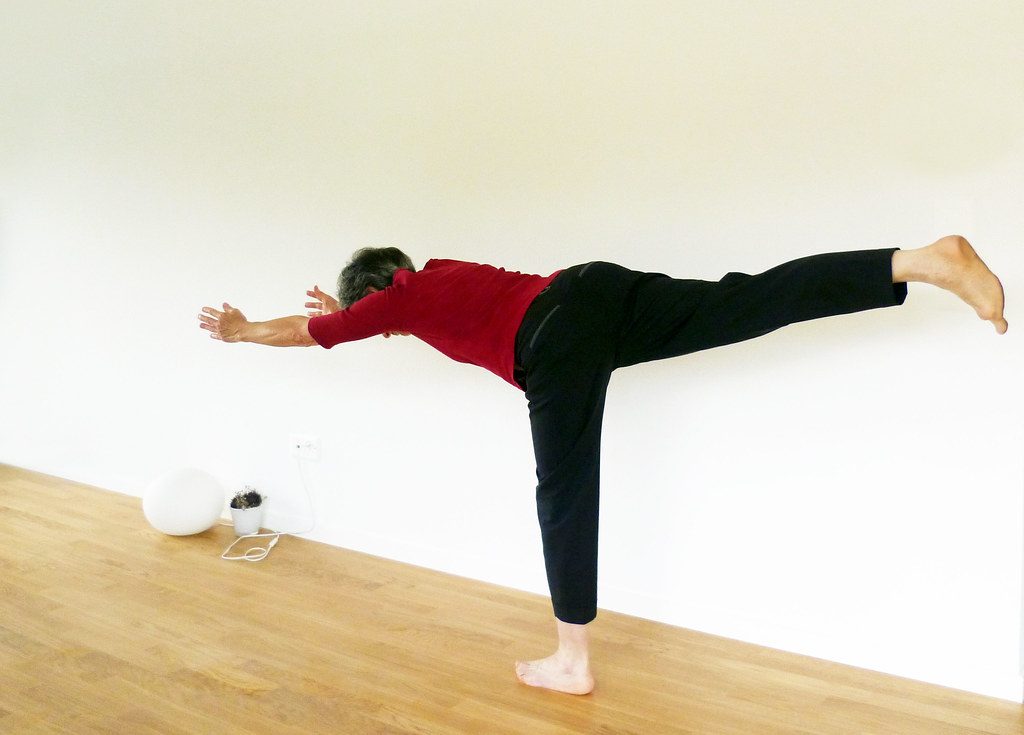 Man in warrior III yoga pose