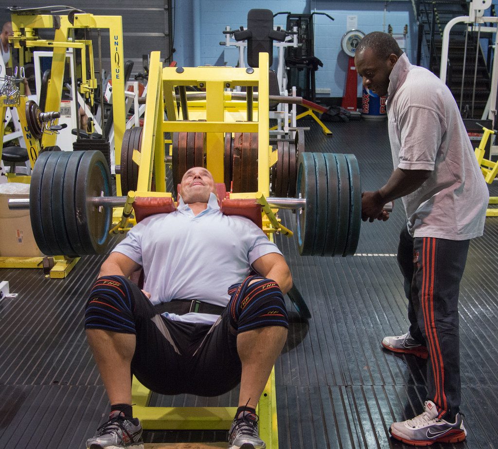 Man on leg press with spotter