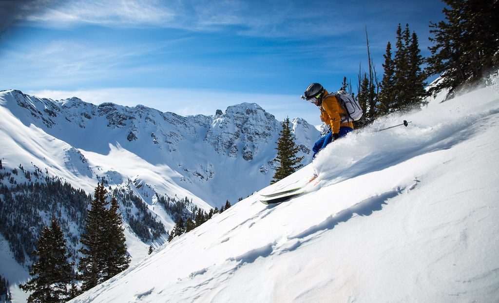 Skier carving down snowy slope