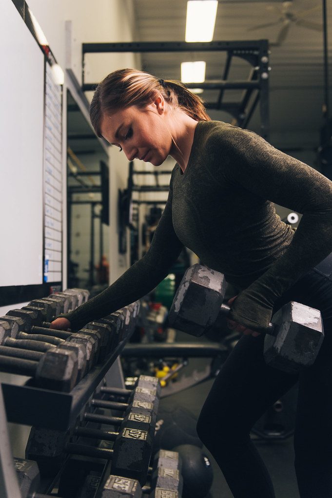 Woman at dumbbell rack in gym