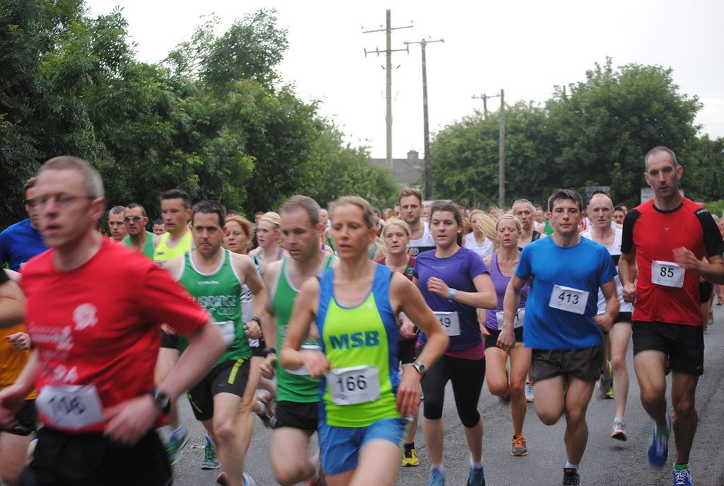 Crowd of runners racing on road