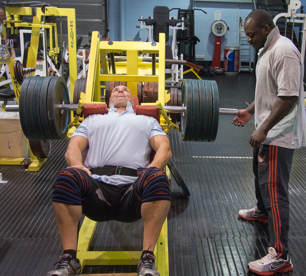 Man on leg press with spotter
