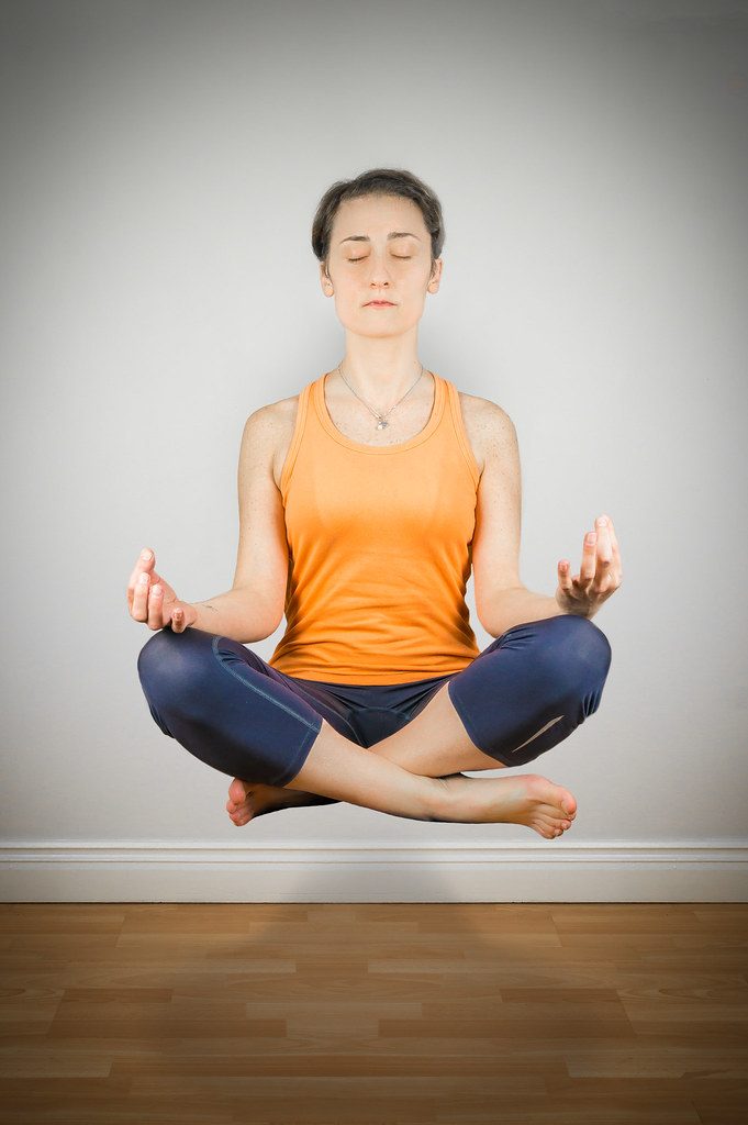 Woman levitating in lotus pose (trick photo)