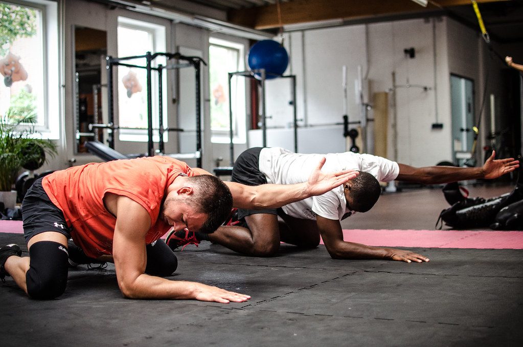 Men stretching on gym floor