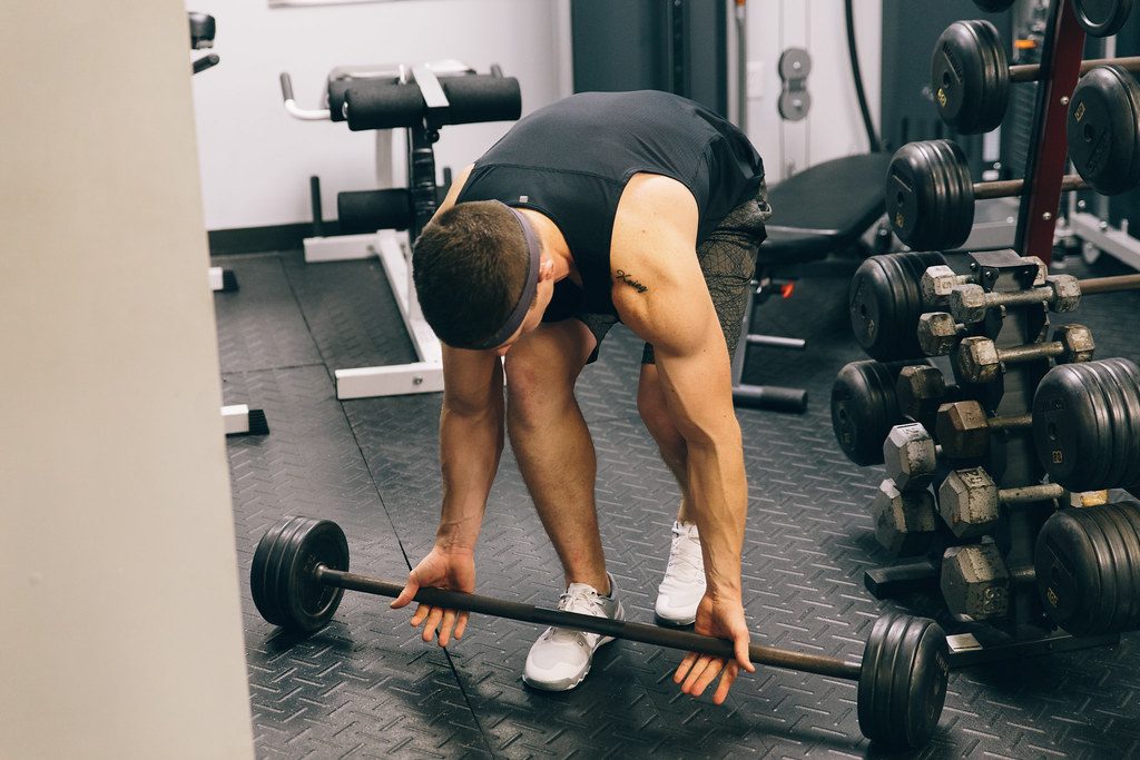Man picking up barbell in gym