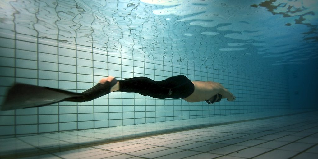 Underwater freediver with monofin in pool