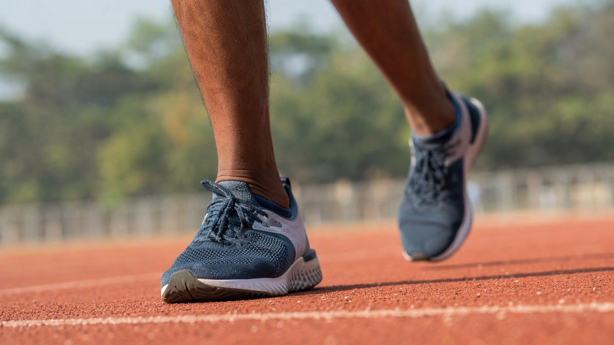 Close-up of a runner mid-stride on a track, focus on foot strike and shoes